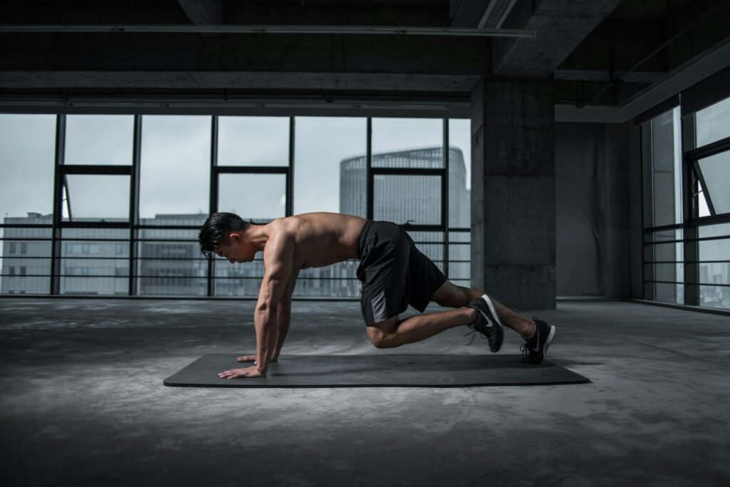 Fit man doing mountain climbers exercise inside a modern gym. Fitness goals