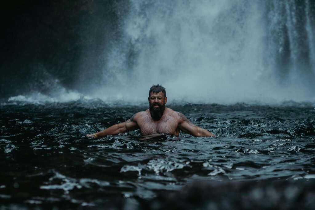 A bearded man enjoys a refreshing swim in a waterfall pool at Cascade Locks, Oregon.