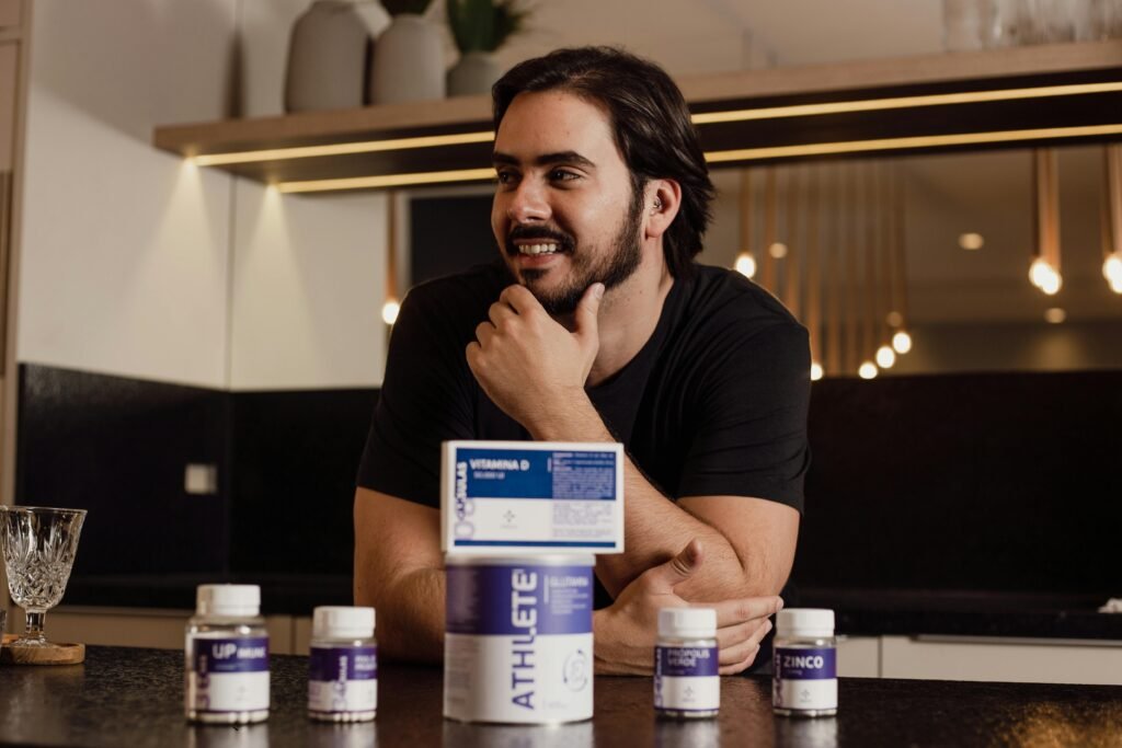 A man enjoying wellbeing surrounded by supplement bottles in a modern kitchen Top 5 Stress Relief Supplements for Athletes: Calmer Minds, Better Recovery