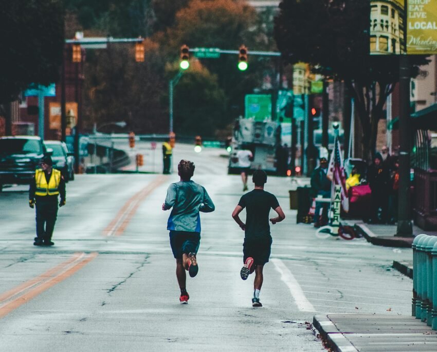 Athletes running a marathon on a street in Wheeling, WV, showcasing urban exercise and lifestyle.