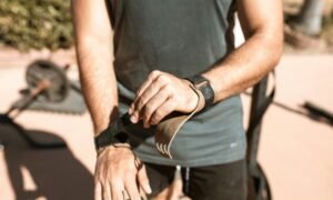 Close-up of a man preparing for an outdoor workout by adjusting his wrist straps.