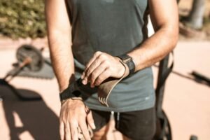 Close-up of a man preparing for an outdoor workout by adjusting his wrist straps.