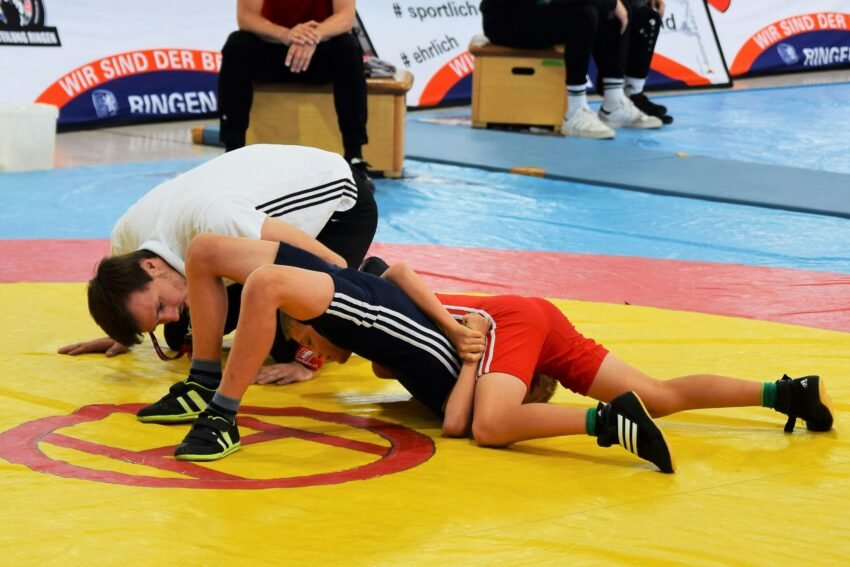 Two young wrestlers engage in a competitive match during an indoor sports event.